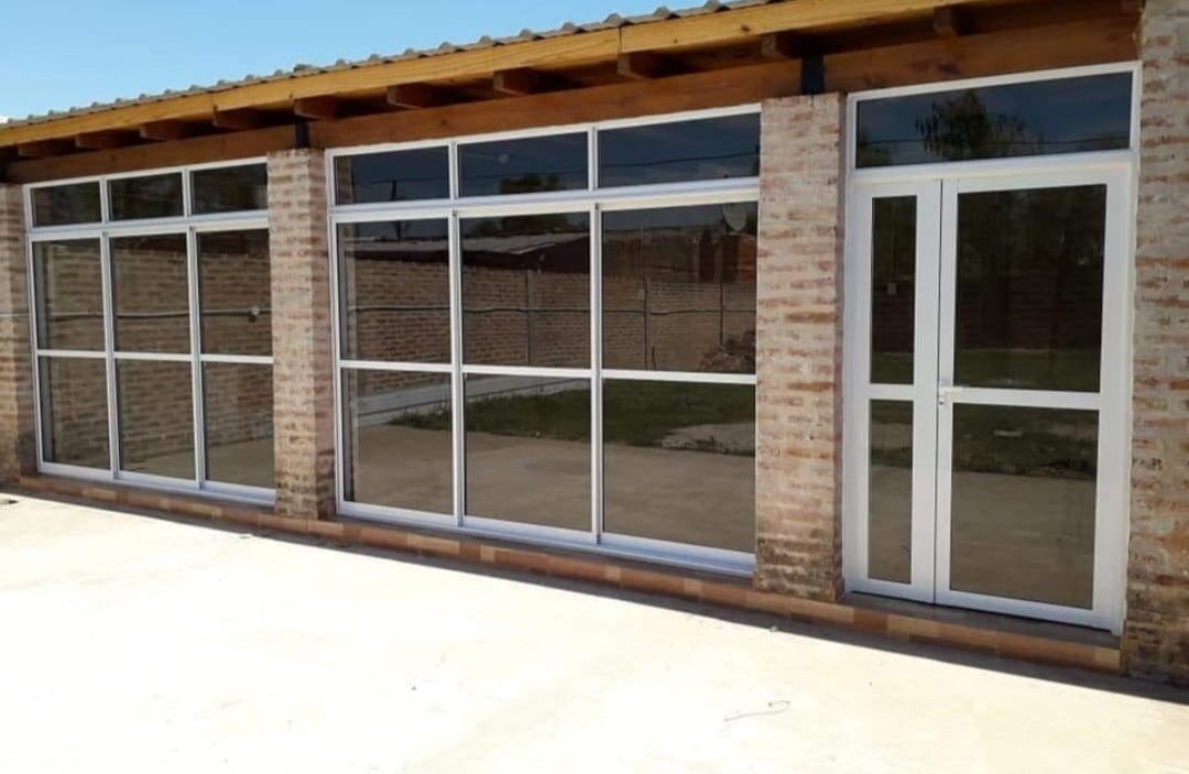 Ventanales de aluminio blanco en una casa de ladrillo