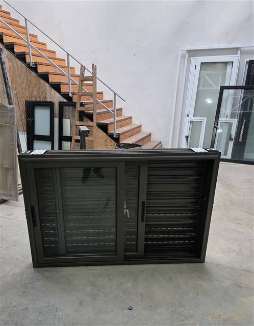 Ventana corrediza marrón con celosía