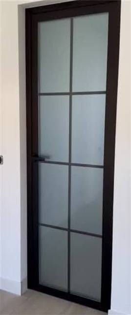 Puerta negra con vidrio repartido esmerilado