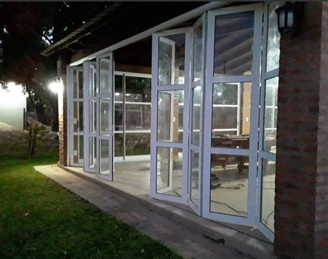 Galería cerrada con aberturas plegables de aluminio y vidrio